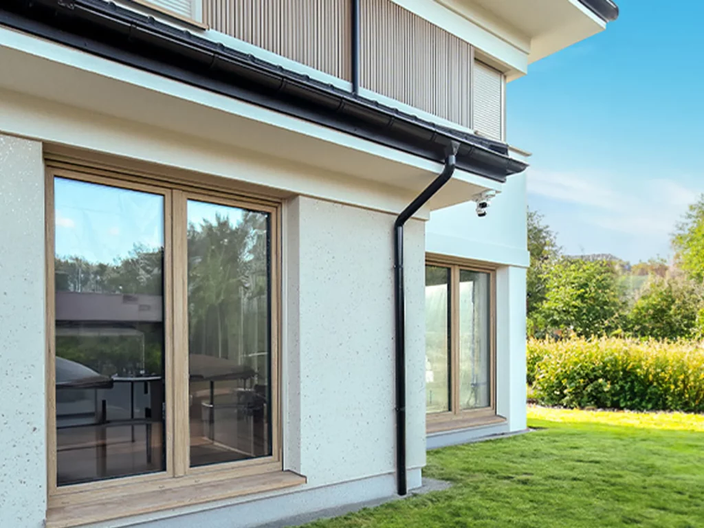 Moderne woning met licht houten kozijnen en grote ramen, gezien vanaf de tuinzijde.